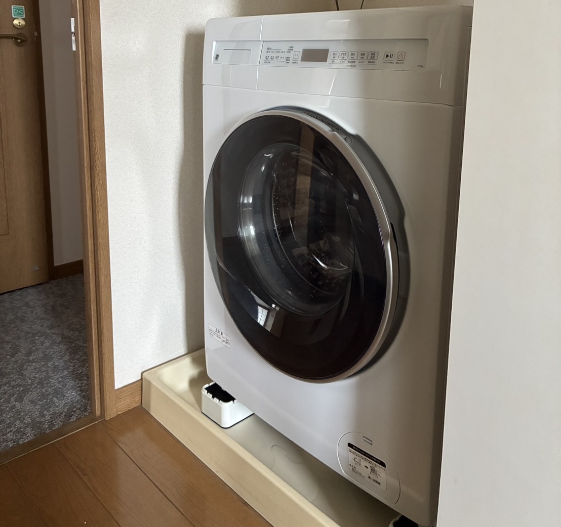 置き場所に収まった白いドラム式の洗濯乾燥機